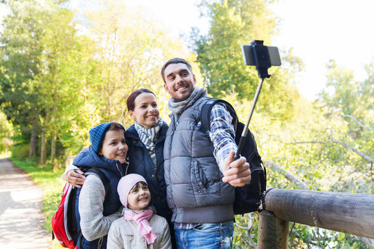 family with backpacks taking selfie and hiking