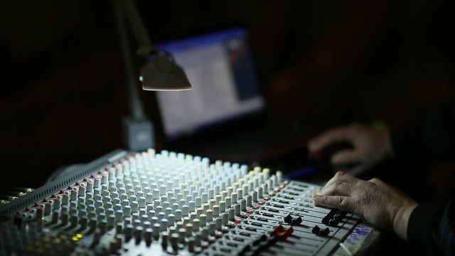 Professional's Hand Working On Audio Mixer In Studio