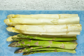 Fresh white and green asparagus on the blue board