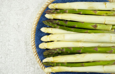 Fresh white and green asparagus on the blue plate