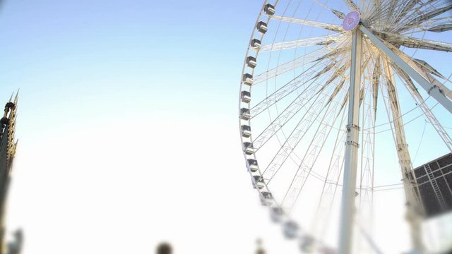 Many people coming to theme park to have fun on huge Ferris wheel, entertainment