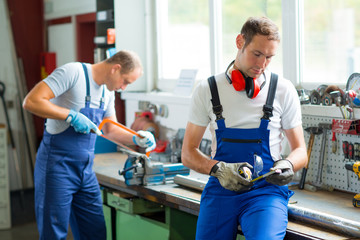  two worker on work bench in factory