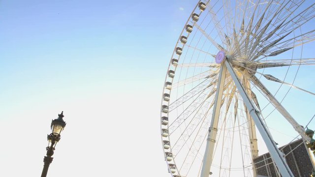 Huge Ferris wheel against blue sky background, beautiful sunny day in theme park