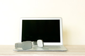Wireless headset and Computer laptop on wooden table