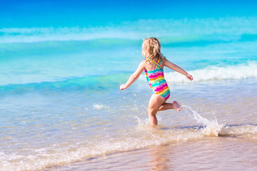 Fototapeta premium Little girl playing on tropical beach