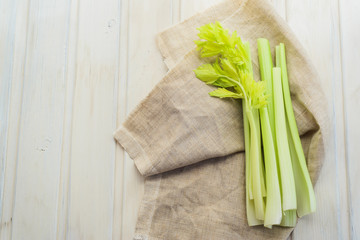 Raw fresh rustic concept, Celery on a white rag on the wooden background
