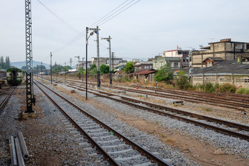 Obraz premium Railroad tracks line of a Public Thai Train Railway, train railway scene from passenger, go travel and journey by thailand train transportation
