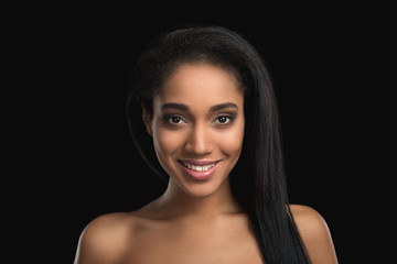 Portrait of smiling handsome nude woman on dark background. Attractive, satisfied, cheerfull african american girl