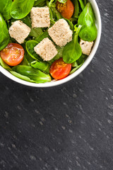 Vegan tofu salad with tomatoes and lamb's lettuce
on slate