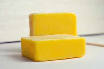Soap bar flavor with mango ingredient isolated on wooden board b