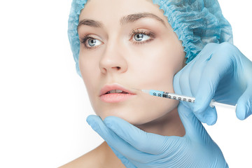 Attractive woman at plastic surgery with syringe in her face