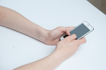 Girl holding a white smartphone. White background