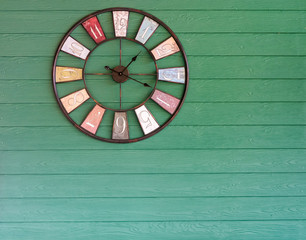 Clock analog green wooden wall background.