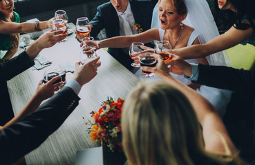 Happy friends of wedding couple and groomsman with bridesmaids at cafe cheers glasses