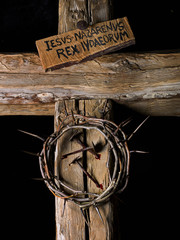 Crown of thorns and nails of Christ with blood on wooden cross