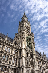 Fototapeta na wymiar Marienplatz, Munich, Germany: Clock tower and part of the facade of the New Town Hall (Neues Rathaus) in the center of the capital of Bavaria