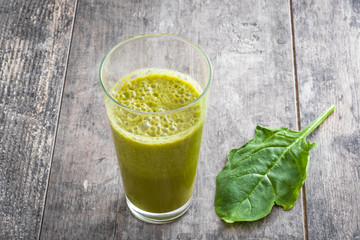 Healthy green detox with spinach, cucumber, lime and apples on a rustic wooden table
