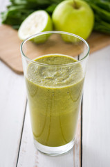 Healthy green detox with spinach, cucumber, lime and apples on white wooden table
