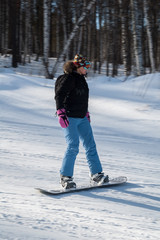 Female snowboarder on the slopes on sunny day