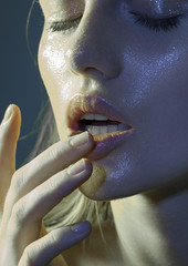 beautiful girl with wet face and fingers next to lips