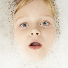 Cute little boy in bathroom with foam. Making funny faces