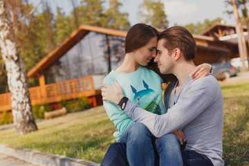 Cheerful couple standing in front of new house