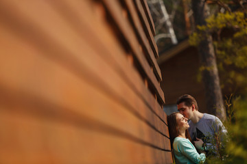 Young happy couple near a wooden house in the country