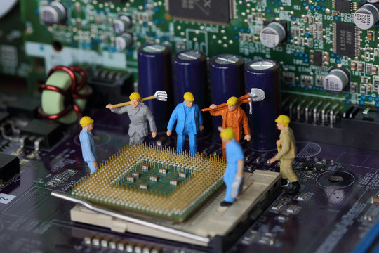 Selective focus of miniature engineer worker to fixed and repair Control Processing Unit (CPU) processor,  mainboard computer and use for industry background.