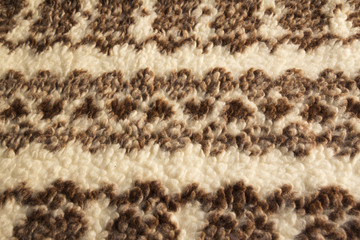 Close-up of knit fabric background with knitted grey and white geometric pattern