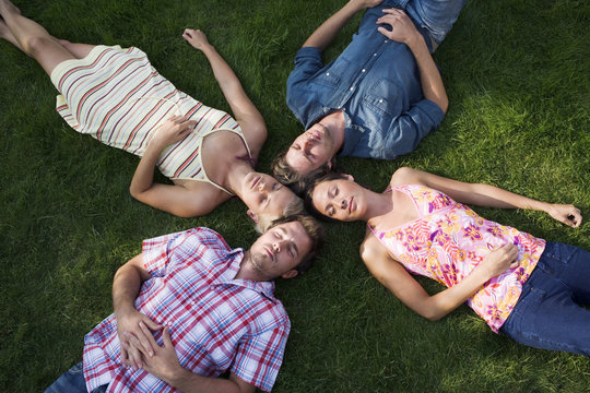 Four people lying on a lawn, Sweden.
