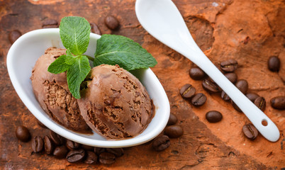 Coffee ice cream with mint leaves in a white Cup