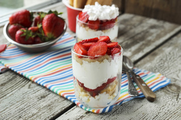 Strawberries dessert with biscuit and cream served on glasses