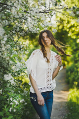 The girl goes on a footpath among a blooming garden 6102.