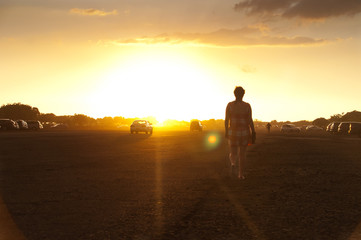 Fototapeta na wymiar Woman walking to the sun