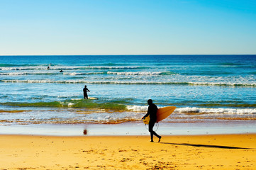 Fototapeta na wymiar Surfers on a beach
