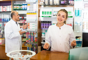 Pharmacist and assistant working at farmacy reception