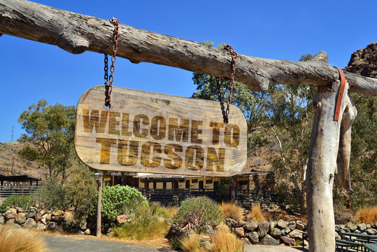 wood signboard with text " welcome to Tucson" hanging on a branch