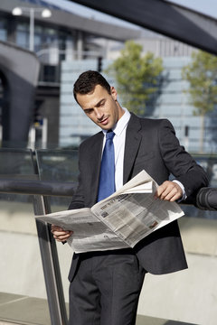 A businessman reading the paper on the airport, Denmark.