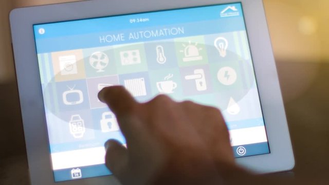 smart house, smart home automation, device with app icons. Man uses his tablet PC with smarthome app to control his house. the new generation of the internet of things.