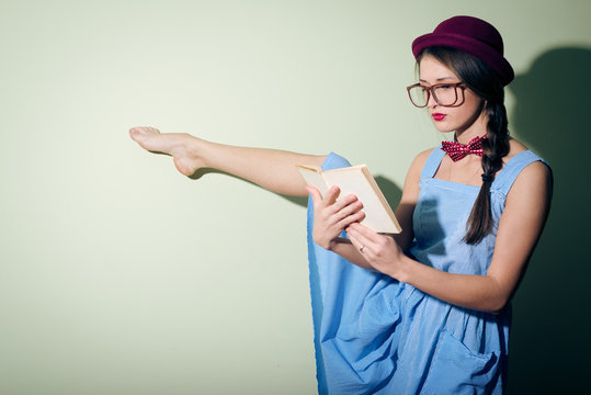 Portrait of pretty ballet dancer in a red hat and glasses reading a book - Powered by Adobe