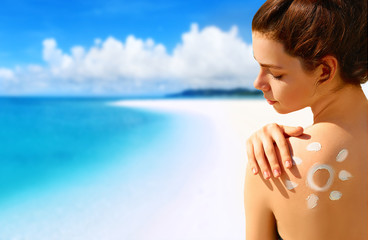 Portrait of gorgeous woman in bikini with the drawn sun on a shoulder at beach