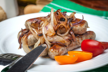 Fried Fried white sausages with onion on the plate.white sausage