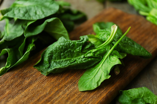 Fresh spinach leaves with cutting board