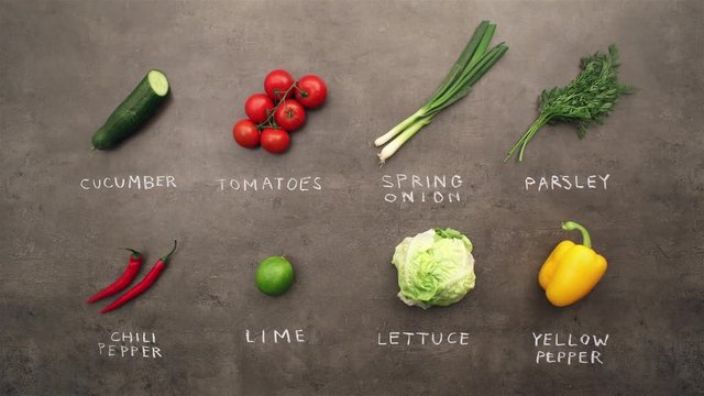 Multiple ingredients and vegetables with chalky signs changing on grey kitchen table. Flat lay recipe & food preparation concept. Stop motion animation.