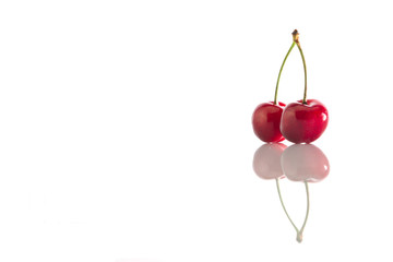 Two cherries on a white background