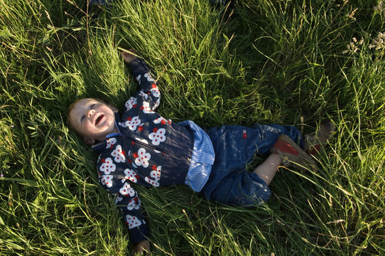 A child playing in the green grass, Sweden.