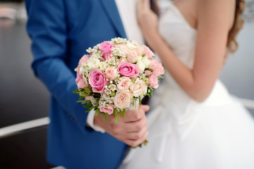 Wedding couple with bouquet. Female and male portrait. Beautiful model girl in white dress. Man in suit. Beauty bride with groom. Woman in bridal gown. Cute lady and guy outdoors