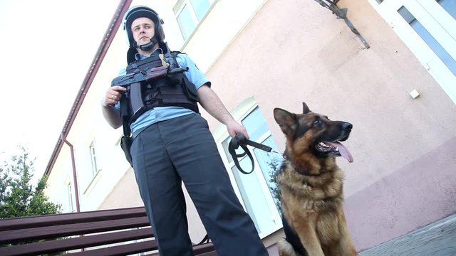 A police officer with a gun and a dog