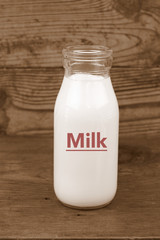 Milk and old style bottle on wood table