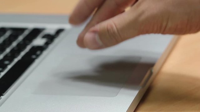 Closeup of fingers using a laptop touchpad to zoom in and swipe sideways as if the users was browsing through photo galleries